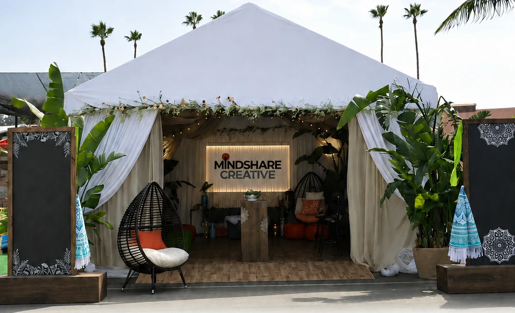 Mindshare Creative branded festival cabana activation surrounded by tropical plants