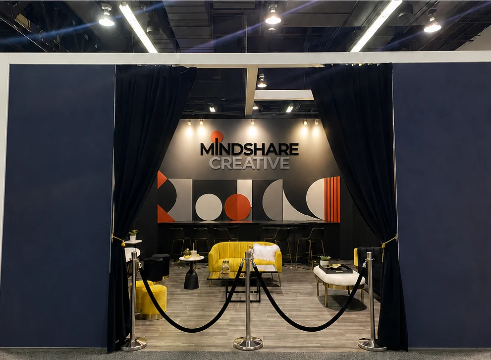 Mindshare Creative tradeshow booth with lounge seating and a branded back wall